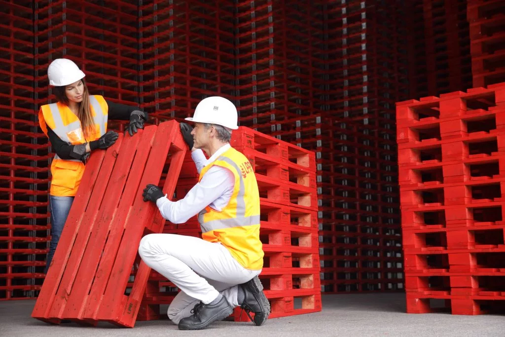 Pallet stacks with signs reading rent a pallet and buy pallets